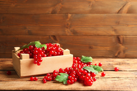 Delicious red currants and leaves on wooden table. Space for textの写真素材
