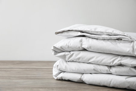 Soft folded blanket on wooden table, closeup. Space for textの写真素材