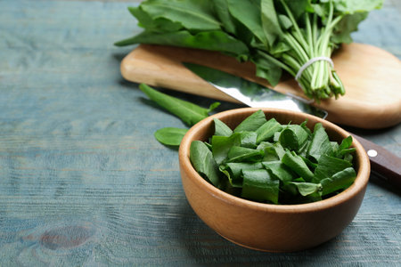 Fresh green sorrel leaves on light blue wooden table, closeupの写真素材