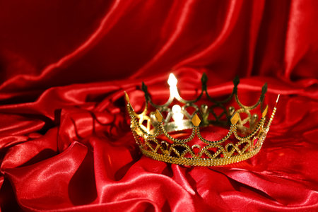 Beautiful golden crown on red fabric. Fantasy itemの写真素材