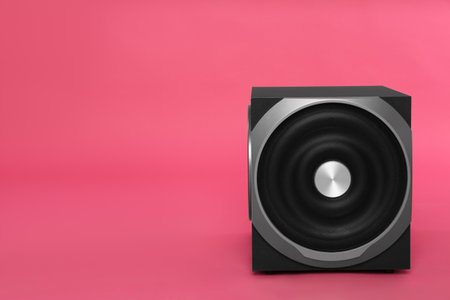 Modern subwoofer on pink background, space for text. Powerful audio speakerの写真素材