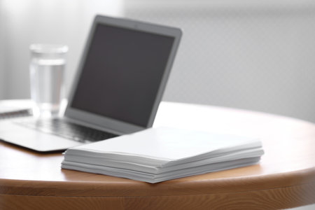 Stack of blank paper sheets on wooden table in office, closeupの写真素材