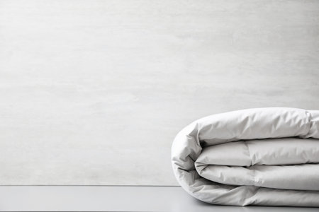 Soft folded blanket on light gray table, closeup. Space for textの写真素材