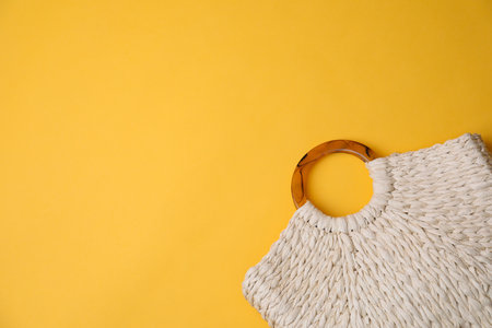 Stylish straw bag on yellow background, top view with space for text. summer accessoriesの写真素材