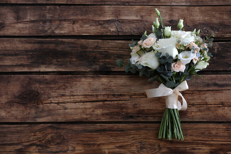 Beautiful wedding bouquet on wooden table, top view. Space for textの写真素材
