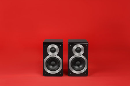Modern powerful audio speakers on red backgroundの写真素材