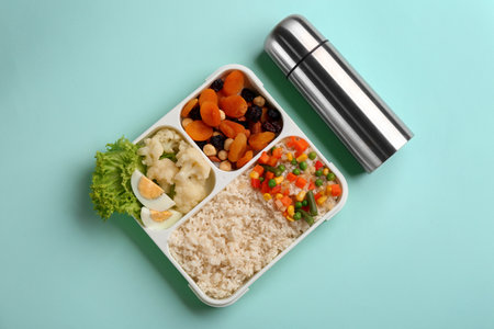 Thermo and lunch box with food on turquoise background, flat lay