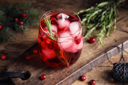 Tasty refreshing cranberry cocktail with rosemary on wooden table, closeupの写真素材