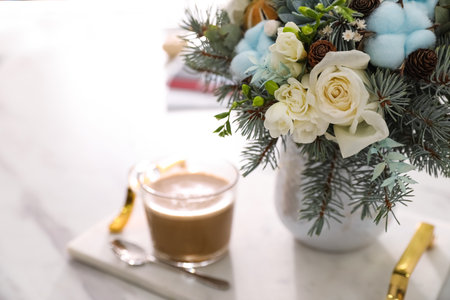 Beautiful winter wedding bouquet and cup of coffee on white marble table tray, closeupの写真素材