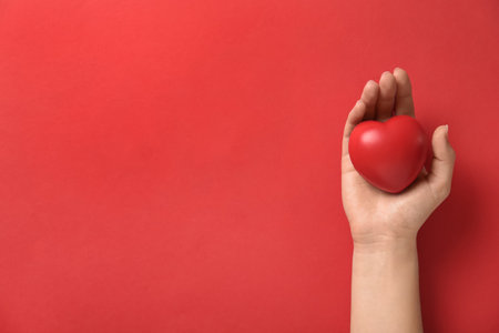 Woman holding decorative heart on red background, top view with space for text. Happy Valentine's Dayの写真素材