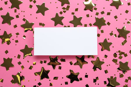 Blank card and shiny golden confetti on pink background, flat lay. Space for textの写真素材