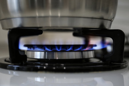 Pot on modern kitchen stove with burning gas, closeupの写真素材