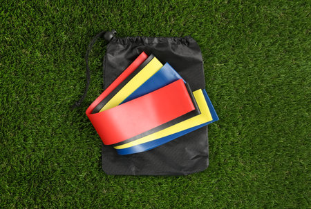 Bag with fitness elastic bands on green grass, top viewの写真素材