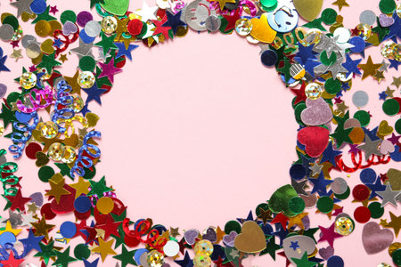 Frame made of bright confetti on pink background, flat lay. Space for textの写真素材