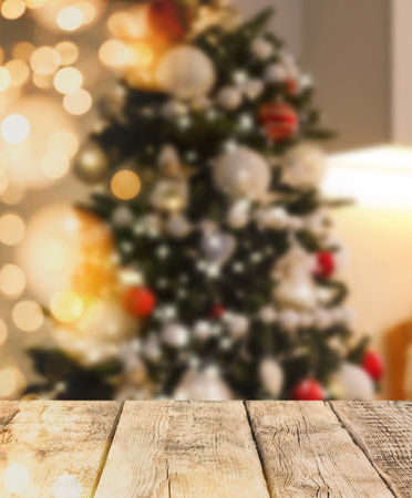 Empty wooden surface and blurred view of Christmas tree in room, space for text. interior designの写真素材
