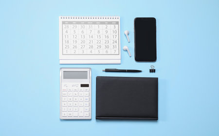Smartphone and stationery on light blue background, flat layの写真素材