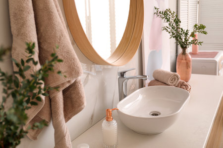 Vase with beautiful branches and fresh towels near vessel sink in bathroom. interior designの写真素材
