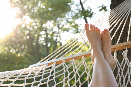 Woman resting in comfortable hammock at green garden, closeupの写真素材