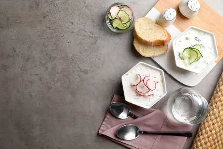 Delicious cold summer soup on grey table, flat lay. Space for textの写真素材