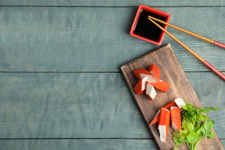 Fresh crab sticks with soy sauce served on wooden table, flat lay. Space for textの写真素材
