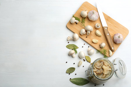 Glass jar of pickled mushrooms on white wooden table, flat lay. Space for textの写真素材