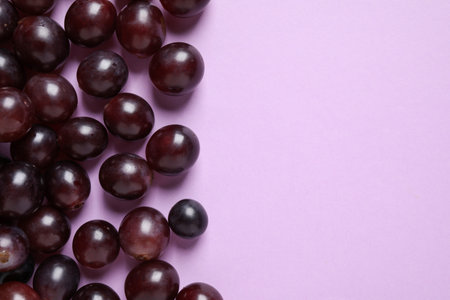 Fresh ripe juicy grapes on pink background, flat lay. Space for textの写真素材