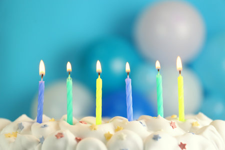 Birthday cake with burning candles on blurred background, closeupの写真素材