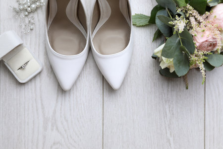 Flat lay composition with wedding high heel shoes on white wooden floor. Space for textの写真素材