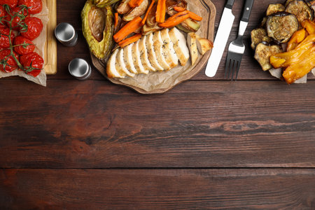 Tasty cooked chicken fillet and vegetables served on wooden table, flat lay with space for text. Healthy meals from air fryerの写真素材