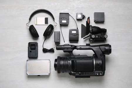 Flat lay composition with camera and video production equipment on light grey backgroundの写真素材
