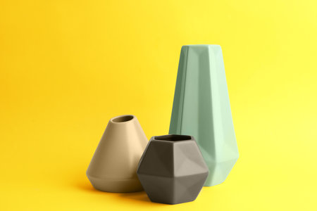 Stylish empty ceramic vases on yellow backgroundの写真素材