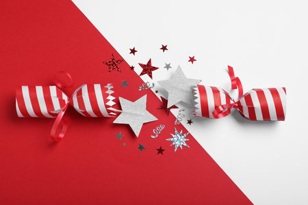 Open Christmas cracker with shiny confetti on color background, top viewの写真素材