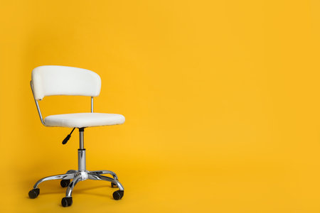 Modern office chair on yellow background. Space for textの写真素材