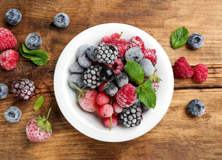 Mix of different frozen berries on wooden table, flat layの写真素材