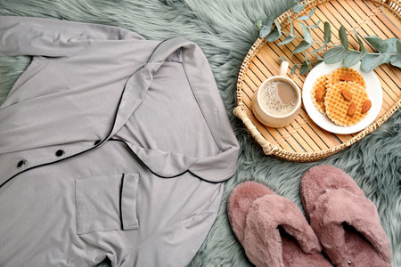 Flat lay composition with fluffy slippers and pajamas on fuzzy carpet. Comfortable home outfitの写真素材