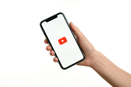 MYKOLAIV, UKRAINE - JULY 9, 2020: Woman holding  iPhone X with Youtube app on white background, closeupのeditorial素材