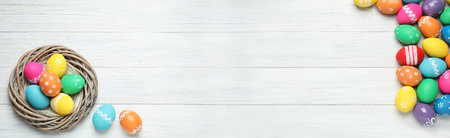 Flat lay composition with colorful Easter eggs on white wooden background, space for text....