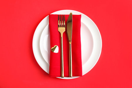 Beautiful table setting for romantic dinner on red background, top view. Valentine's day celebrationの写真素材