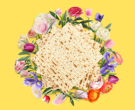 Tasty matzos and flowers on yellow background, flat lay. Passover (Pesach) celebrationの写真素材