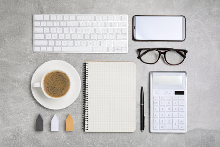 Flat lay composition with computer keyboard, calculator and notebook on gray tableの写真素材