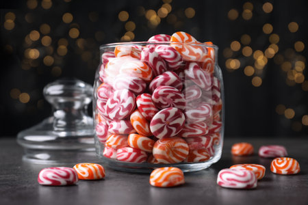 Glass jar with colorful hard candies on dark tableの写真素材