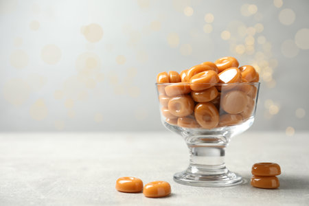 Dessert bowl filled with tasty candies on light table. Space for textの写真素材