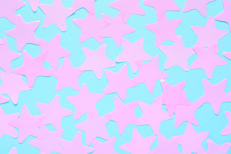 Pink star shaped confetti on light blue background, flat lay