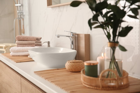 Fresh towels and beautiful branches near stylish vessel sink in bathroom. Interior designの写真素材