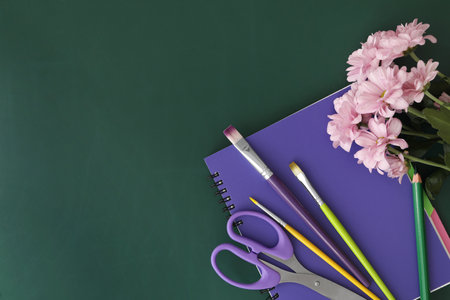 Different school stationery and beautiful pink flowers on green chalkboard, flat lay with space for text. Happy Teacher's Dayの写真素材