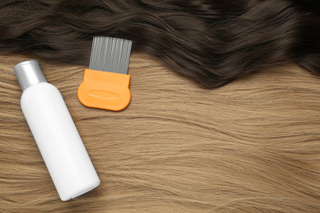 Comb and anti lice shampoo on hair, flat lay. Space for textの写真素材
