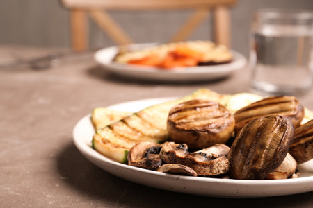 Delicious grilled vegetables and mushrooms served on grey table, closeupの写真素材