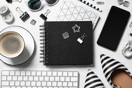 Flat lay composition with notebook and cup of coffee on light table