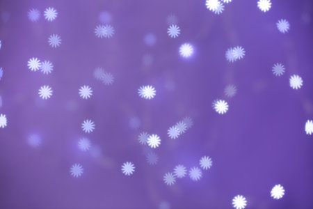 Beautiful snowflake shaped lights on purple background