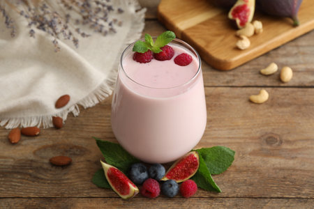 Delicious fig smoothie in glass on wooden tableの写真素材